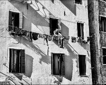 L'asciugatrice Laundry is dried outdoors in Venice; a man is taking the laundry off the clothesline.